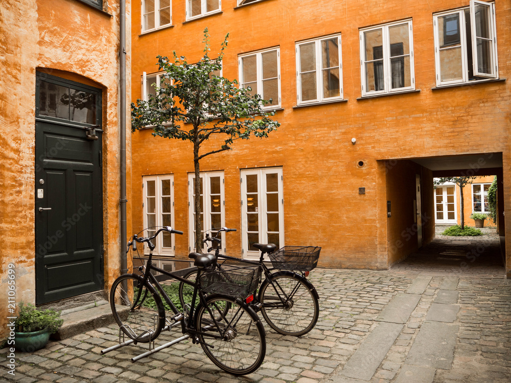 Bicicletas en Copenhague contra una fachada amarilla en el verano de 2017.