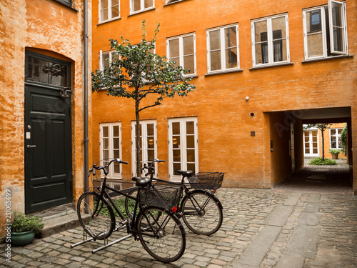 Bicicletas en Copenhague contra una fachada amarilla en el verano de 2017.