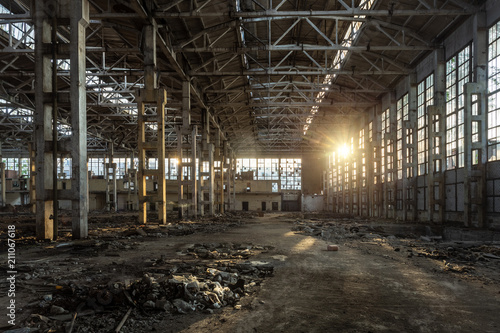 Sunlight of sunset in large abandoned industrial building of Voronezh excavator factory  