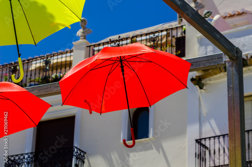Colourful umbrellas urban street decoration. Hanging colorful umbrellas over blue sky  tourist attraction
