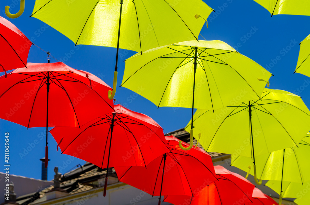 Colourful umbrellas urban street decoration. Hanging colorful umbrellas over blue sky, tourist attraction