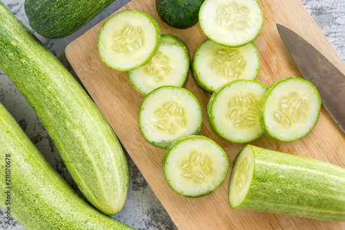 Fresh cucumber slices on a cutting board. Top view