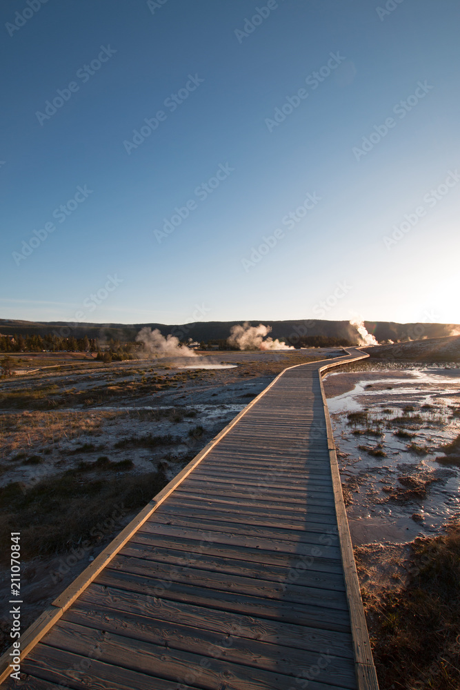 Sunset over boardwalk at the Old Faithful geyser basin in Yellowstone National Park in Wyoming United States