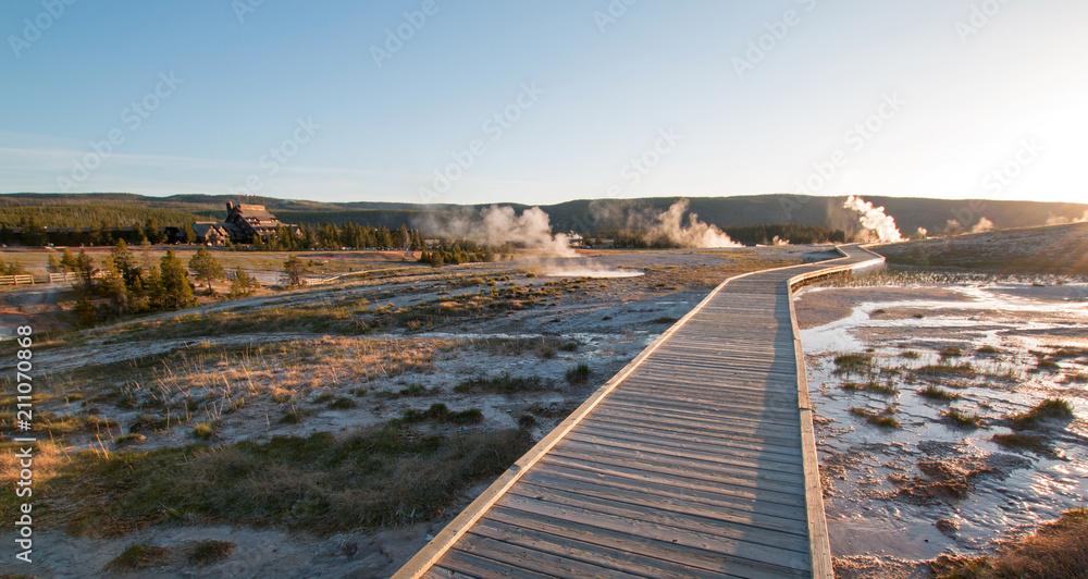 Sunset over boardwalk at the Old Faithful geyser basin in Yellowstone National Park in Wyoming United States