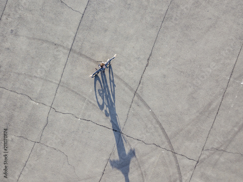 aerial top down view of teenage boy walking with bicycle isolated urban copy space