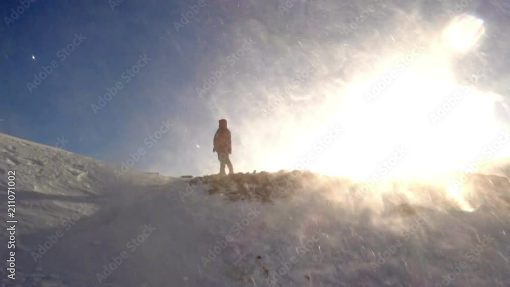 Climber stands on top in a snow blizzard Climber stands on top in a snow blizzard