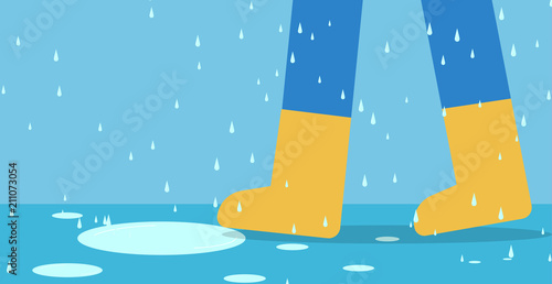 Feet of man in rain boots walk on road with rain