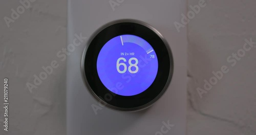Woman Decreasing Temperature of Smart Thermostat Gadget At Home - Close