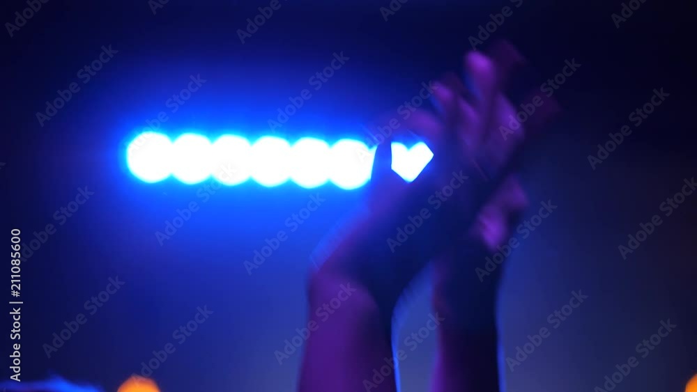Music concert spectator enjoy raise wave hands in rhythm slow motion in stage lumiere light