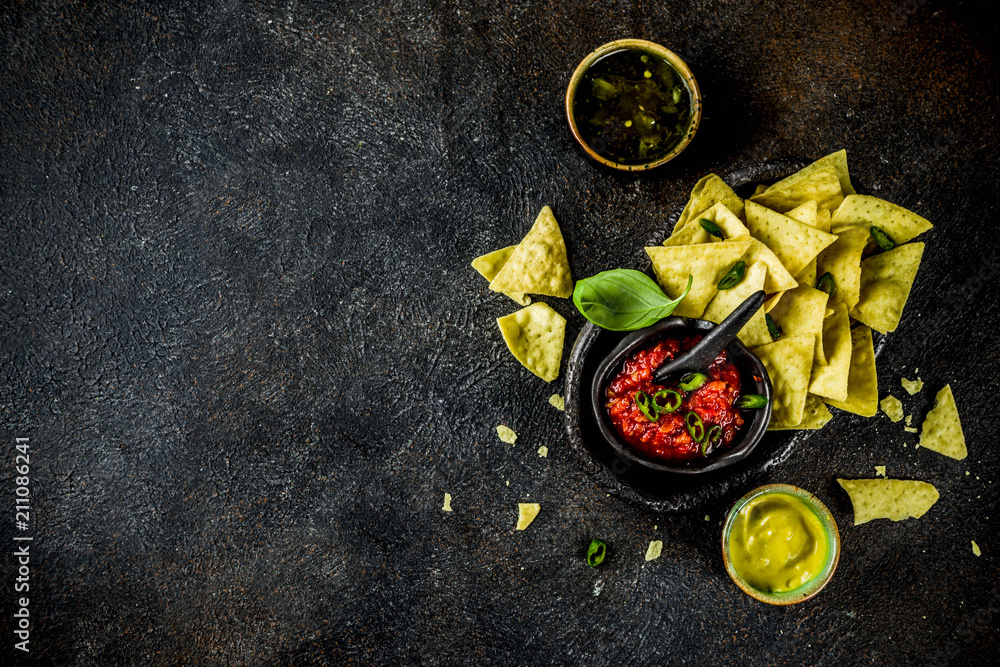 Mexican food, nachos snack with salsa and sauces on dark rusty background top view copy space Mexican food, nachos snack with salsa and sauces on dark rusty background top view copy space