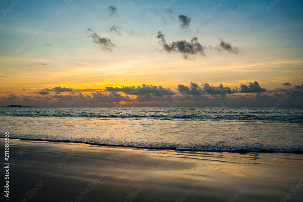 Dramatic sunset sky with clouds over ocean.