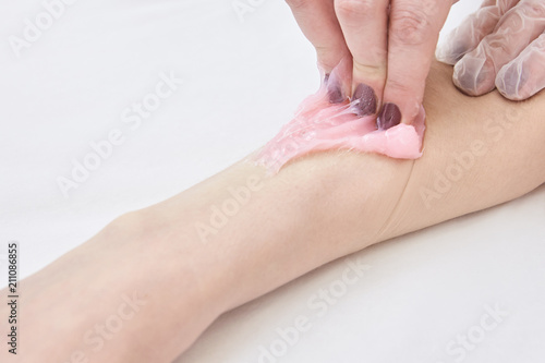 Lady shugaring forearm. Pink shugar depilation at center