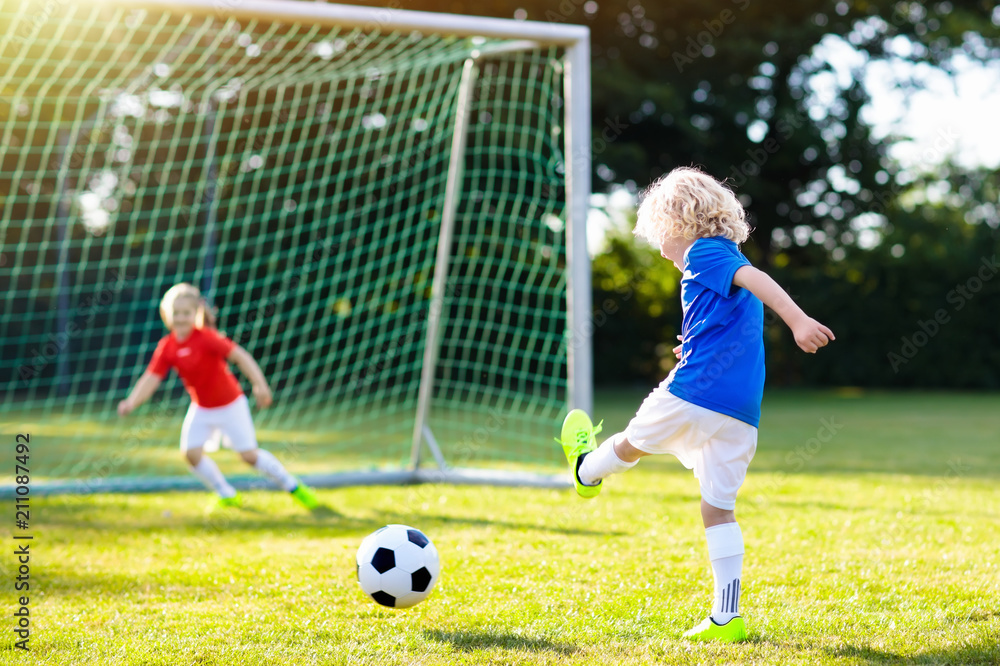 Obraz premium Kids play football. Child at soccer field.