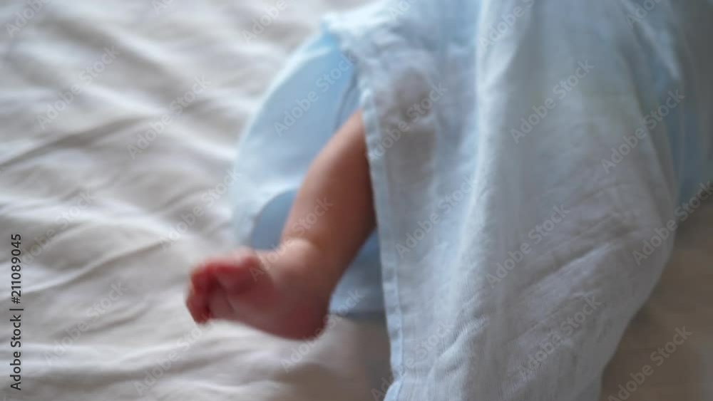 Newborn infant baby little legs and feet when he lying on bad in nappy Newborn infant baby little legs and feet when he lying on bad in nappy