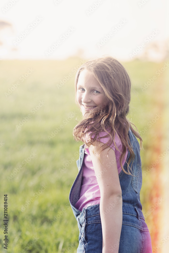happy girl in field, looking back to camera happy girl in field, looking back to camera
