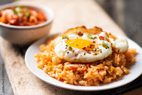 Kimchi fried rice with fried egg on top and fresh kimchi cabbage, Korean food