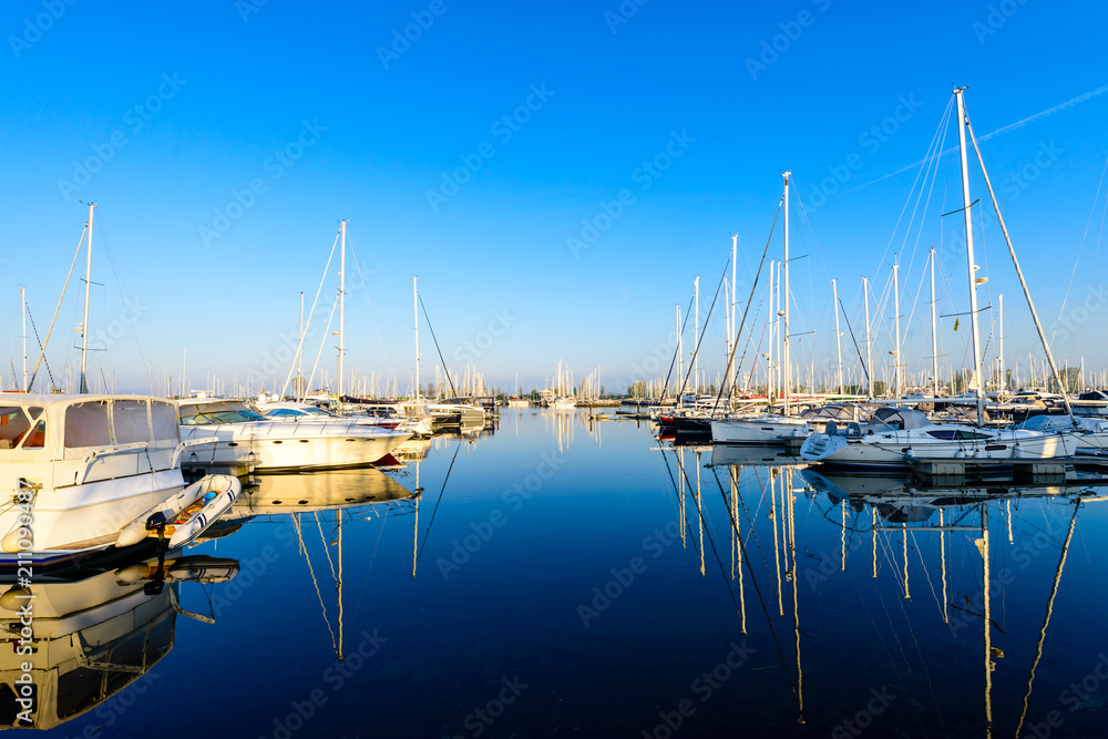 Fototapeta premium Modern sailboats and luxury yachts parked in the seaport on summ
