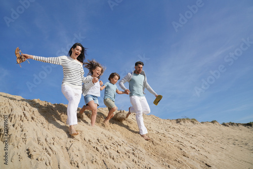 Family running down sand dune