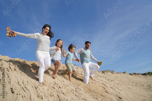 Family running down sand dune