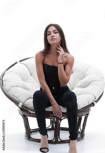 young woman sitting in a comfortable big armchair