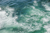 View of foam in green blue water during windy weather, beautiful ocean background