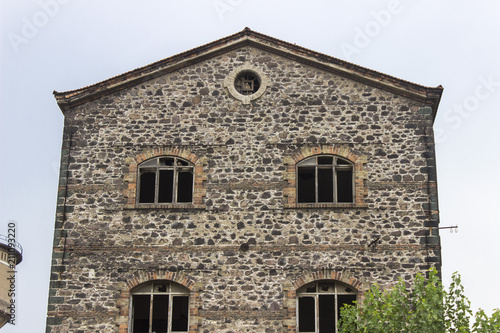 Front wide shot of abandoned masonry stone constructed old tobacco storage building in Izmir at Turkey