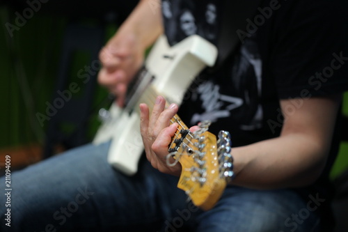 hands of a man playing an electric guitar