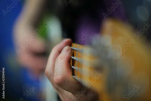 hands of a man playing an electric guitar