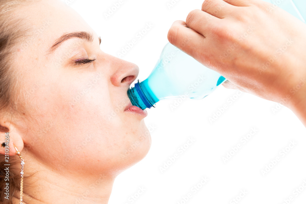 Close-up of young woman drinking water from plastic bottle. Close-up of young woman drinking water from plastic bottle.