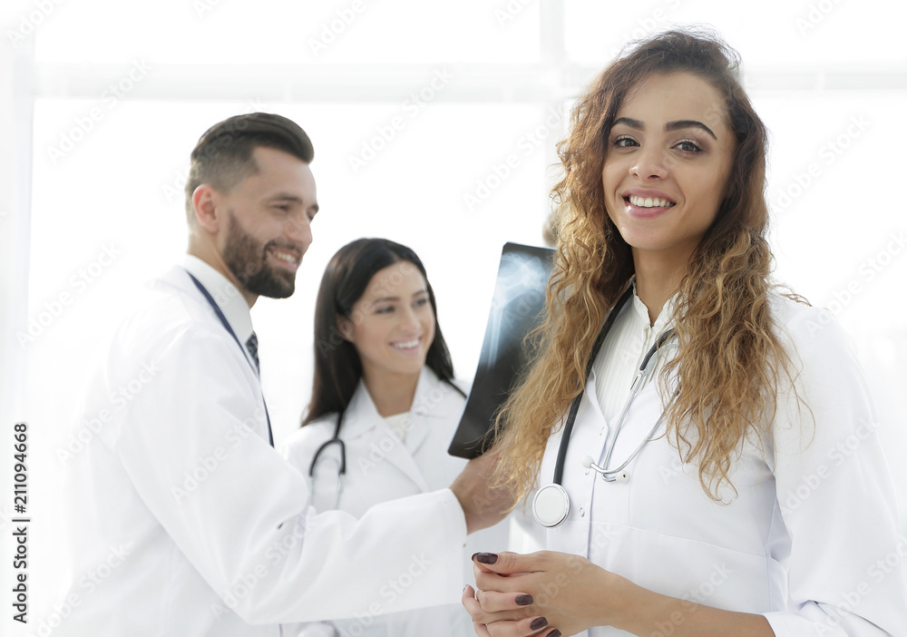 confident doctors in hospital looking at x-ray.