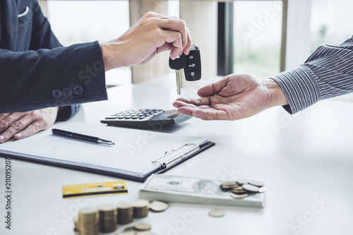 Salesman send key to customer after good deal agreement, successful car loan contract buying or selling new vehicle