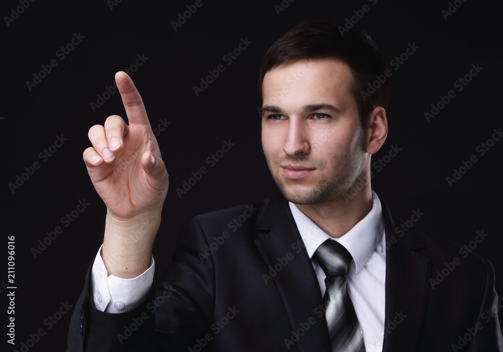 businessman pointing to a blank spot.isolated on a black background. businessman pointing to a blank spot.isolated on a black background.