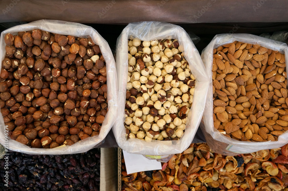 Fresh peeled walnuts, hazelnuts and raisins in the street market. Nut kernel. The concept of organic food