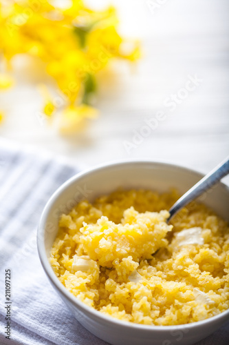 Cooked corn grits with butter in bowl. Dry cereal. Healthy food concept.