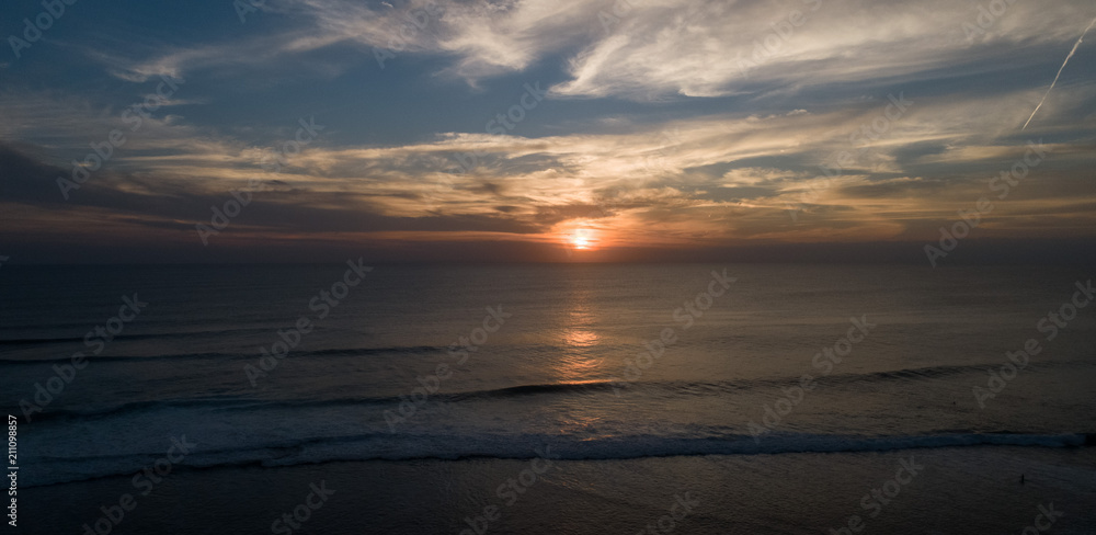 Aerial drone view of sunset on the ocean coast, sea, beach, sky, clouds. Sunset on the island of Bali, Indonesia