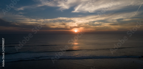 Aerial drone view of sunset on the ocean coast, sea, beach, sky, clouds. Sunset on the island of Bali, Indonesia