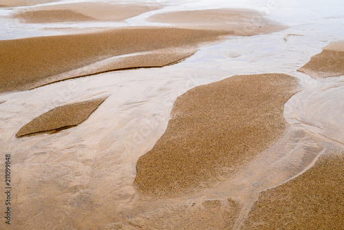 Sand landscape at low tide with water grooves
