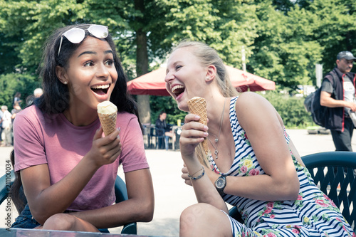Junge Frauen im Stadtpark  tuscheln und lachen  Eis essen
