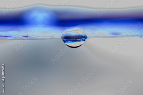 CREATIVE MACRO PICTURE SHOWING WATER DROP FROM A BLUE RULER '' WATER IS SECRET OF LIFE''