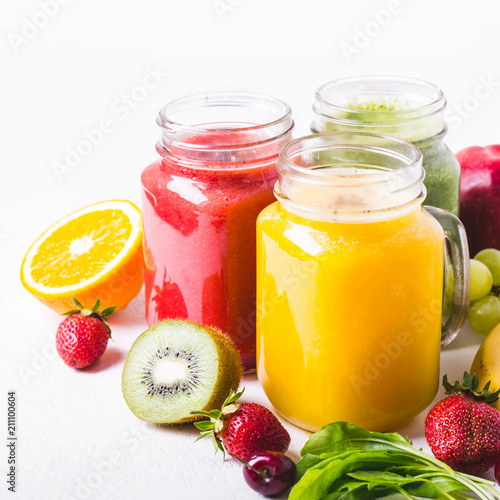Selection of multicolored fruit smoothies in glass jars