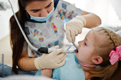 Little baby girl at dentist chair. Children dental.