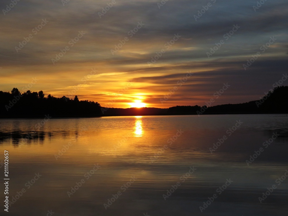 Sunset Over Beautiful Lake with Cloudy Sky in background