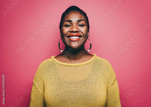 Portrait of smiling mid adult woman against pink background