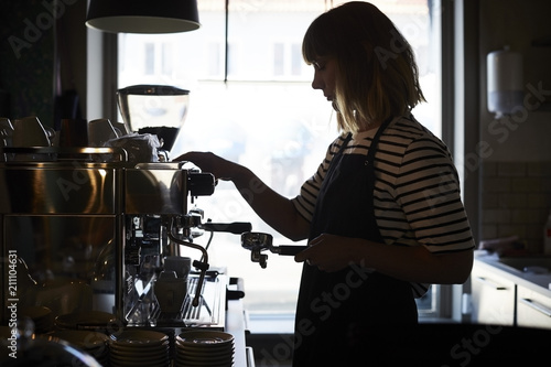 Female barista preparing coffee at cafe photo