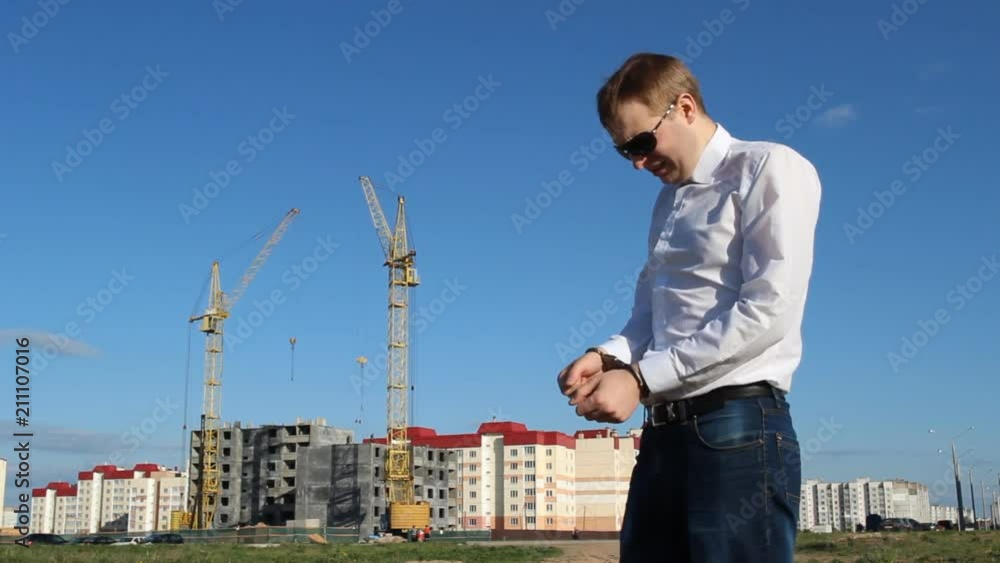 Inspector in handcuffs on the background of construction Inspector in handcuffs on the background of construction