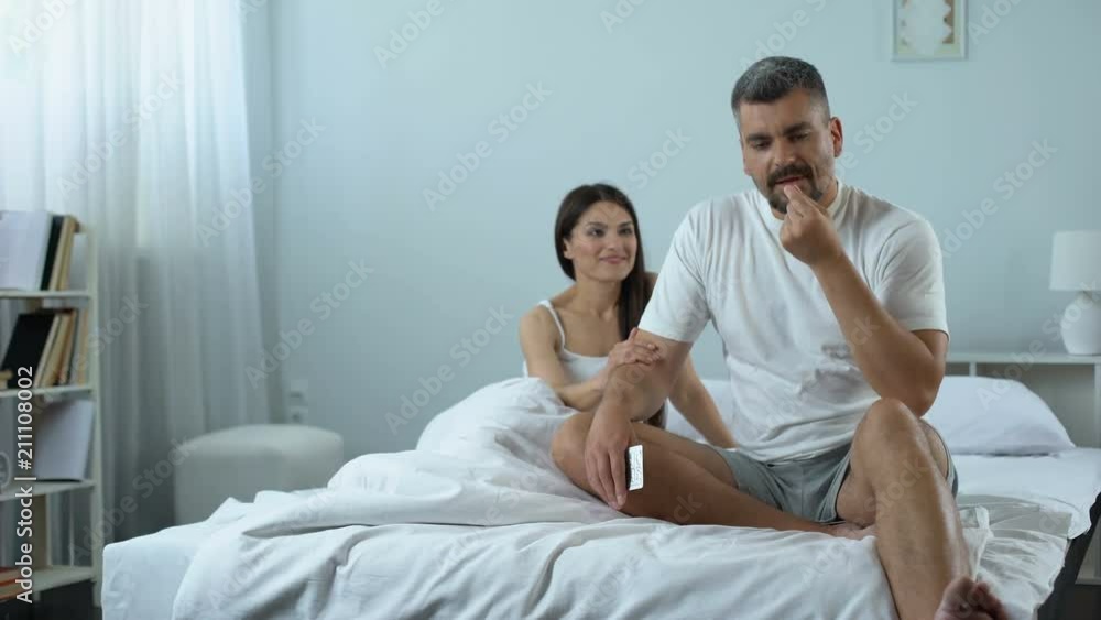 Man taking pill improve sexual desire, libido, pleasant pastime with girlfriend Man taking pill improve sexual desire, libido, pleasant pastime with girlfriend