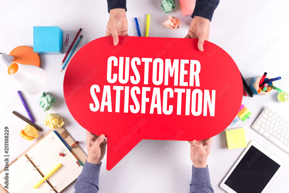 Two people holding speech bubble with CUSTOMER SATISFACTION concept Two people holding speech bubble with CUSTOMER SATISFACTION concept