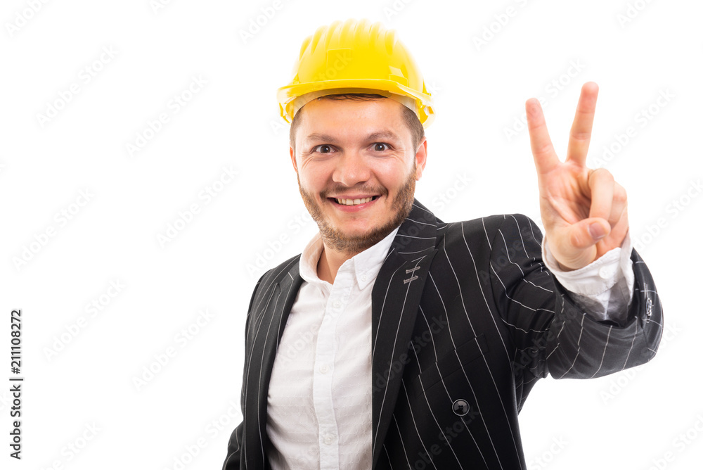 Business man in safety yellow helmet showing victory gesture. Business man in safety yellow helmet showing victory gesture.