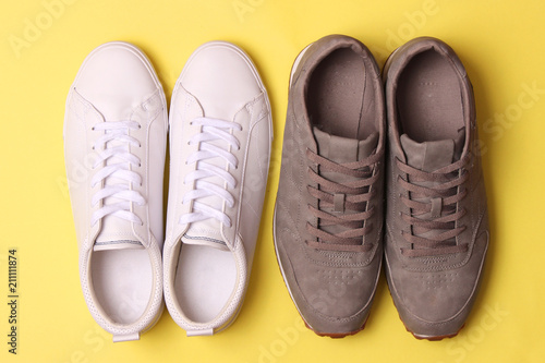 male sneakers and sneakers on a colored background top view. men's footwear. minimalism
