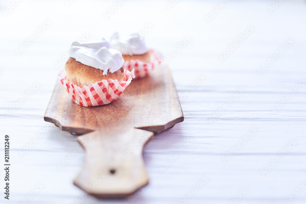 Naklejka premium Cupcakes with white cream on a wooden background